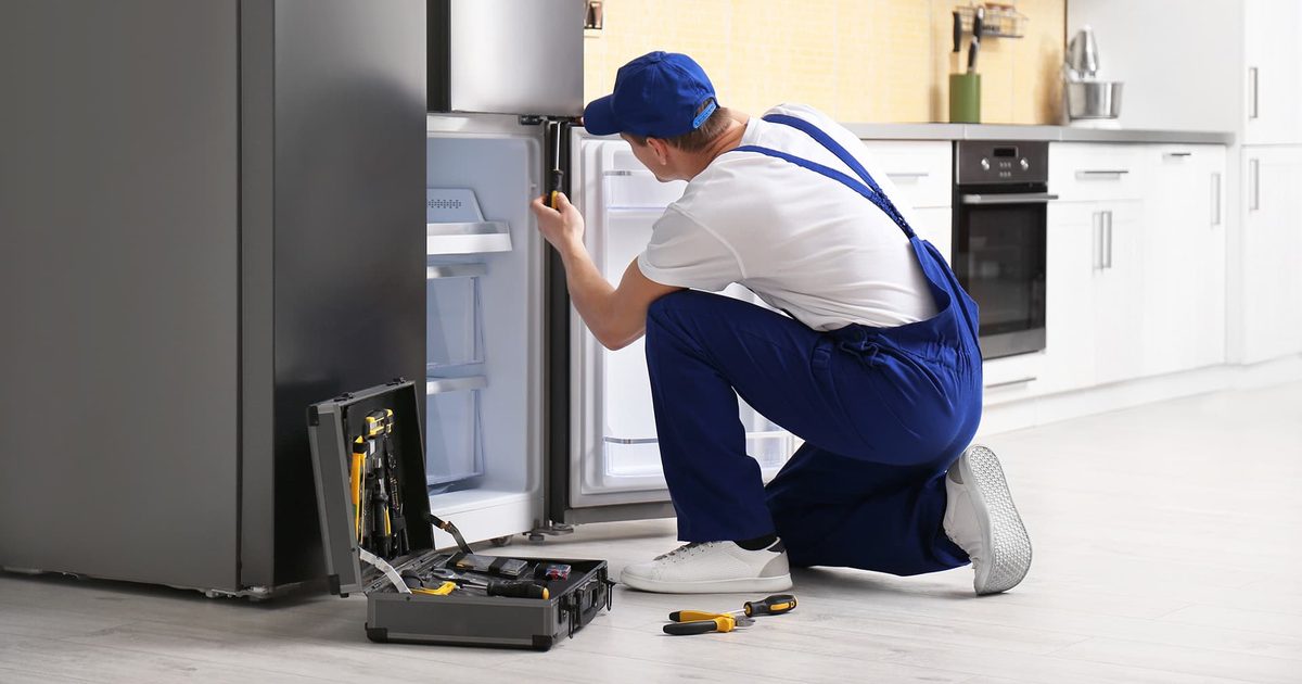 Technician diagnosing a refrigerator that is not cooling